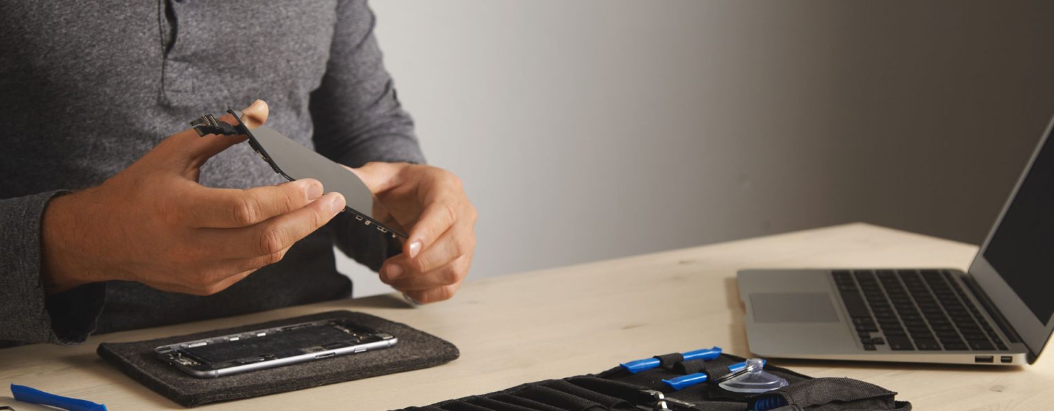 master-holds-new-screen-replacement-disassembled-smartphone-his-laboratory-tool-kit-with-instruments-laptop-front-him-white-table-space-your-text-right